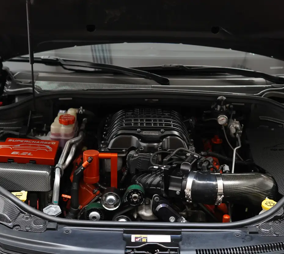 Open hood of a vehicle showing an engine and cold air intake.