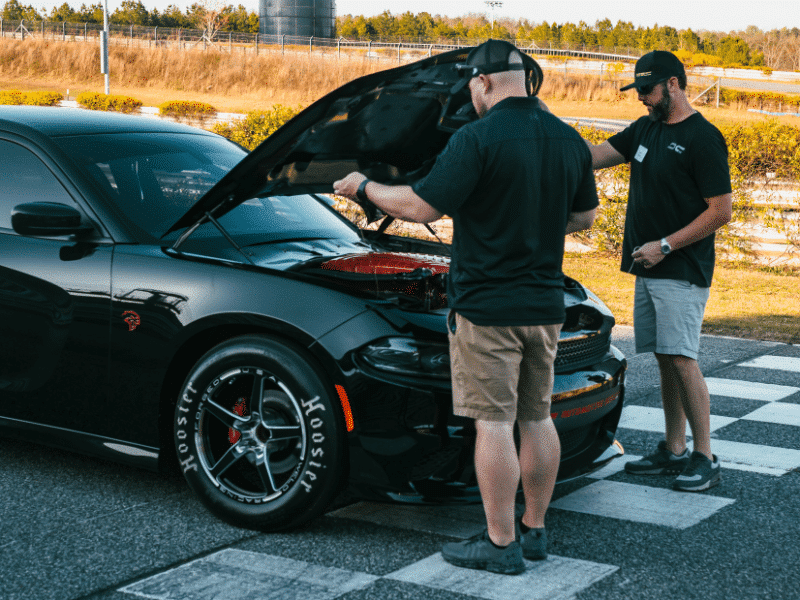 two guys looking over a very powerful hellcat built by dusterhoff racing