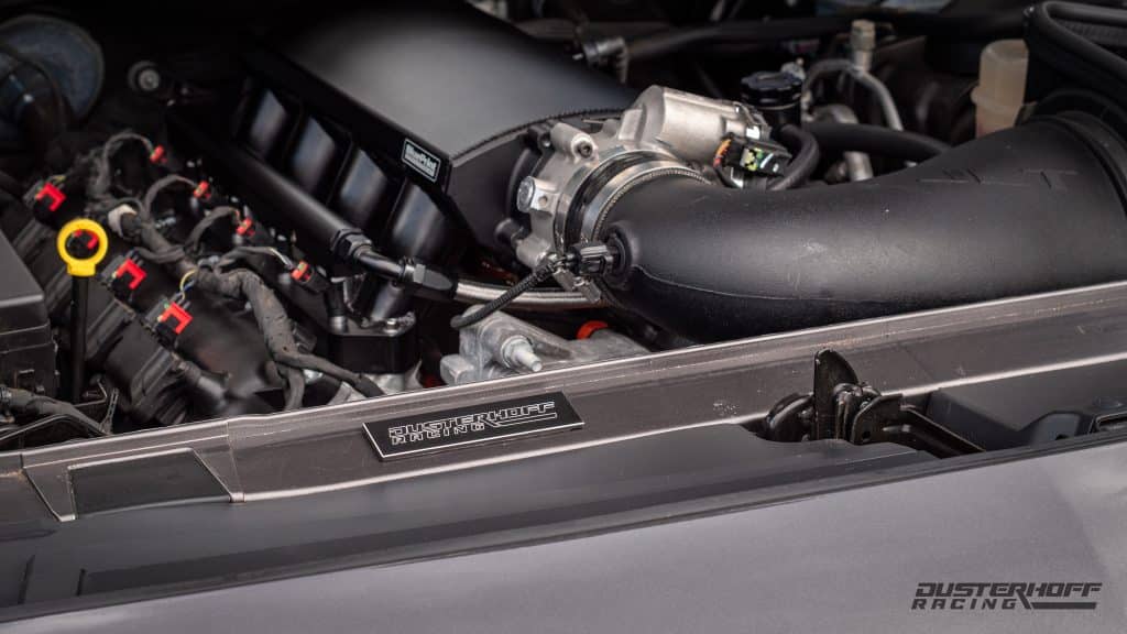 engine bay of T/A Grey Challenger showing off jlt cai and blueprint intake manifold